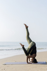 African American woman practicing yoga at the beach
