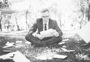 Businessman sitting with a lot of scattered paperwork