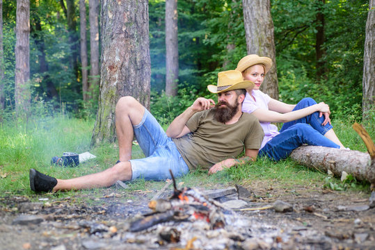 Family activity for summer vacation in forest and nature. Couple relaxing after gathering mushrooms in wild for food. Family traditions. Family relaxing near bonfire after day of mushroom hunting