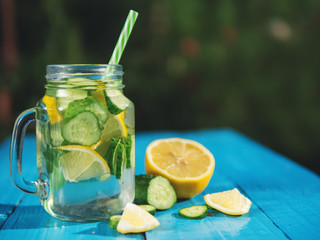 Dietary water. Lemonade with cucumber and mint on wooden table