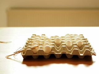 Fresh white farmers chicken eggs in a box on a table .