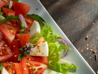 vegetable salad on a white plate, dark background, copy space