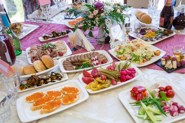 Served tables at the Banquet. Drinks, snacks, delicacies and flowers in the restaurant. A gala event or wedding.