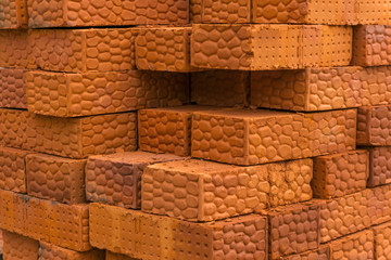 background - stack of textured bricks made of red clay
