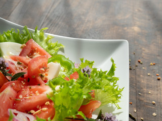 vegetable salad on a white plate, dark background, copy space