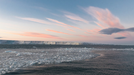 Arctic Norway at pink sunset with packed ice in Svalbard and dynamic cloud lines