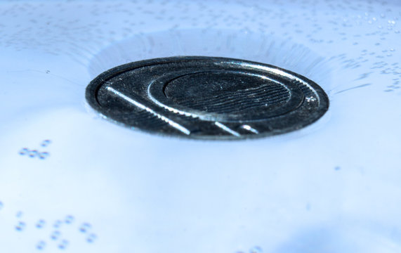 Surface Tension - Isolated Coin In A Glass Of Water - Surface Tension