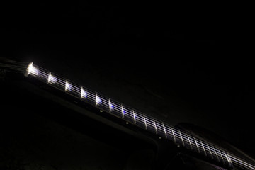 The tuning end of a guitar isolated on a black background.