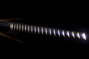 The tuning end of a guitar isolated on a black background.