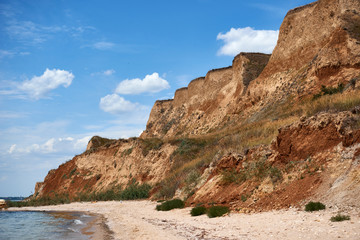 beautiful sea summer landscape, wild beach closeup, sea coast with high hills and cloudy sky