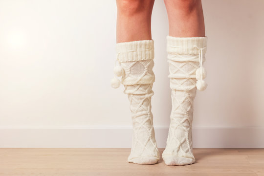 Woman's Feet In Warm Knitted Socks Standing On Toes