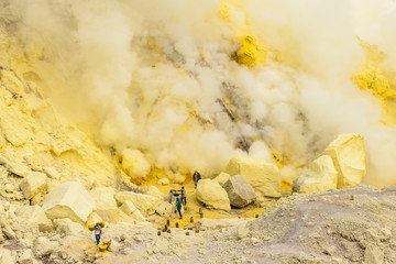 Sulfur hard workers in Indonesia on Ijen volcano in smoke