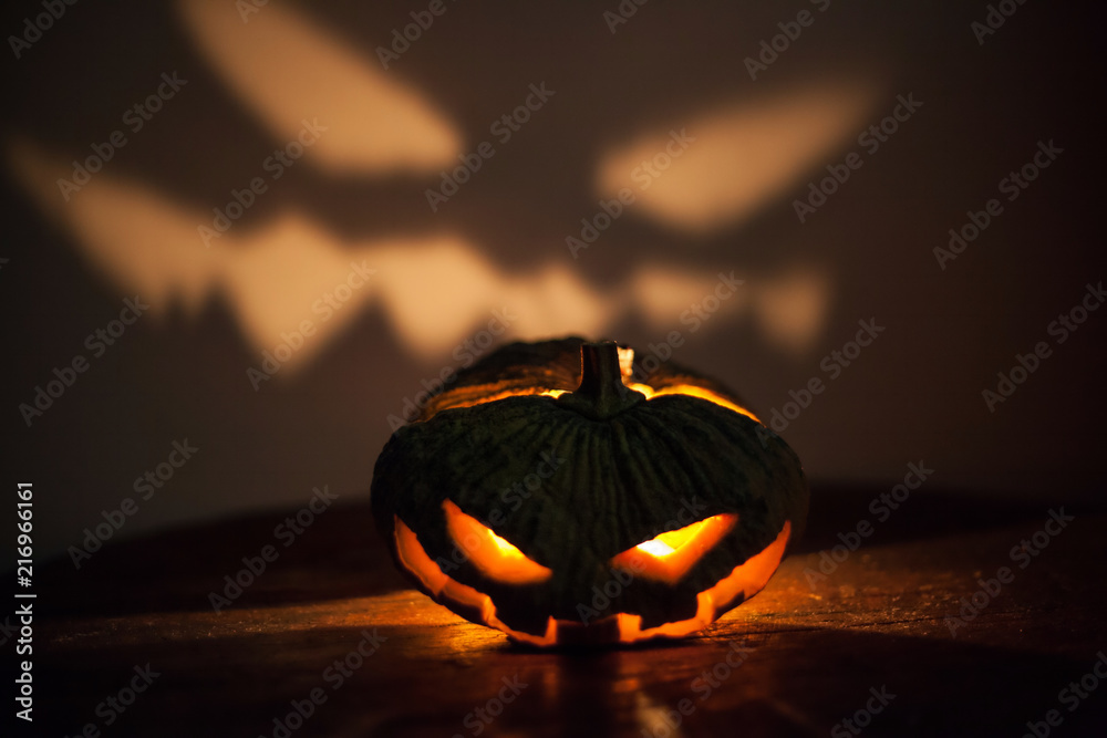 Wall mural Halloween pumpkin head jack lantern with spooky light face on the wall.