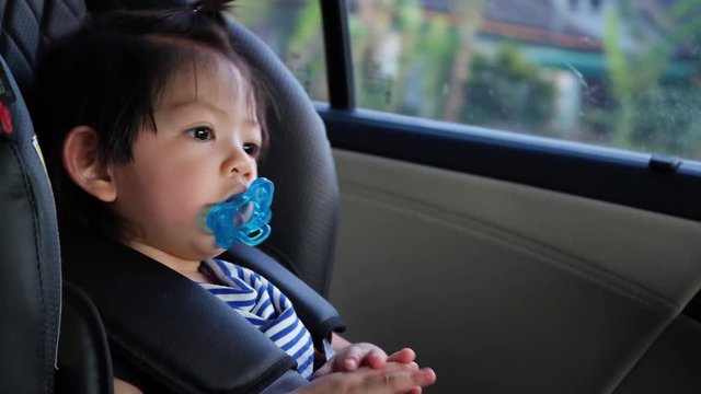 happy baby sitting on car seat with safety driving road trips travel