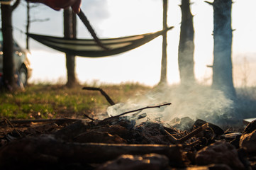 Camping fire with hammock on the background near sea
