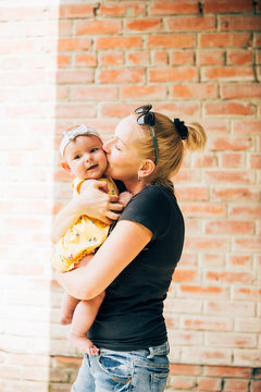 Adorable Baby And Mother Holding In Hands And Smiling Ad Kissing Urban Outdoors Background Sunny Summer