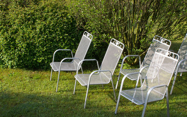 Fototapeta premium Metallic silver chairs in park on grass