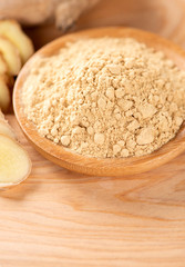 Ginger root, ginger slice and ginger powder on wooden background table, space for text.