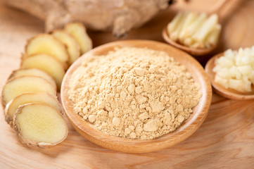 Ginger root, ginger slice and ginger powder on wooden background table, space for text.