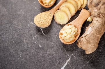 Ginger root, ginger slice and ginger powder on stone background table, space for text.