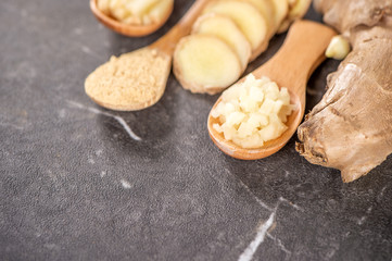 Ginger root, ginger slice and ginger powder on stone background table, space for text.
