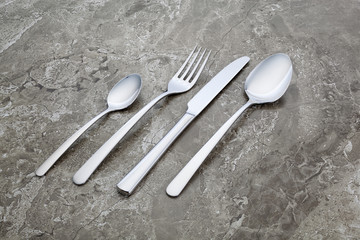 A set of elegant and shining cutlery on a marble background