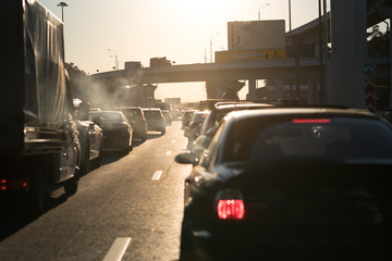 Traffic jam on a hot summer evening. Highway and road junction. Sunset and cars