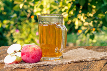 Picked apples and apple cider in glass goblet on wooden boards