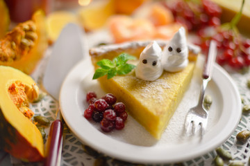 Pumpkin cake, cooked for the celebration of Halloween and decorated with little ghosts. Food photography