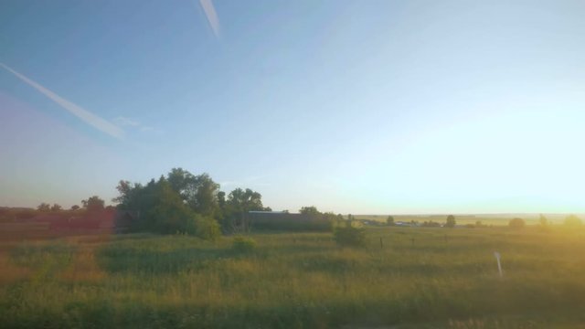 Sunlit fields filmed from a moving vehicle at a high speed