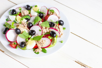 Nicoise salad with tuna, egg, cherry tomatoes and black olives. French cuisine. Top view, copy space