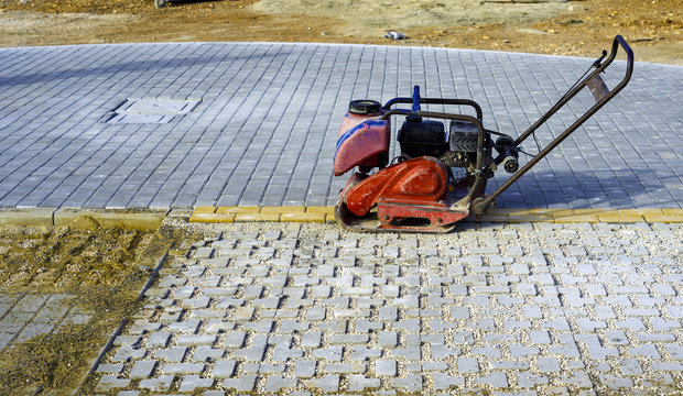 Vibrator with rubber plate for compacting paving with interlocking blocks