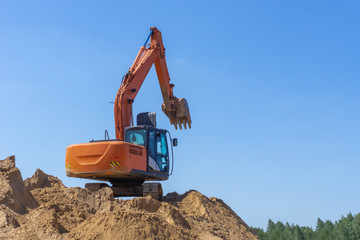 Excavator at the construction site loads the sand