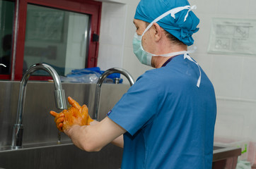 Surgeon is watching his hands ecording to sterilization rules.