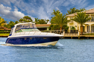 Blue and White Yacht Past Mansions