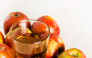 Glass of fresh apple cider near autumn apples