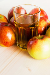 Glass of fresh apple juice near autumn apples