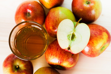 Glass of fresh apple cider near autumn apples