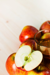 Glass of fresh apple juice and half apple near autumn apples