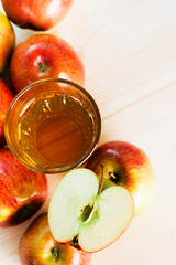 Glass of fresh apple juice and half apple near autumn apples