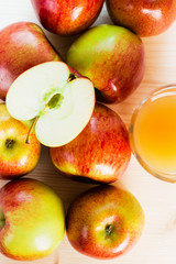 Glass of fresh apple juice and half apple near autumn apples