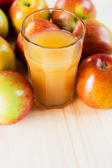 Glass of fresh apple juice near autumn apples