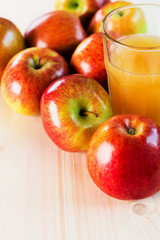 Glass of fresh apple cider near autumn apples