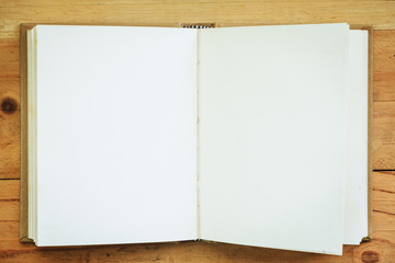 Opened notebook on wooden background for writing notes in