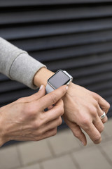 Fototapeta na wymiar Woman's hand adjusting settings of smartwatch, close-up