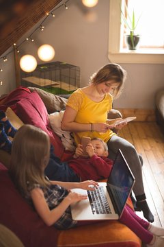 Family on sofa using multimedia devices