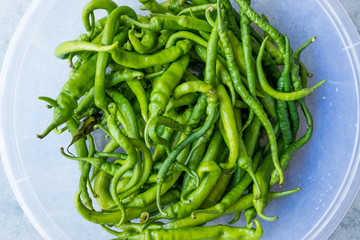 Green Chili Peppers in Transparent Plastic Bowl.