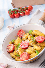 gnocchi baked with green pesto, cherry tomatoes and parmesan