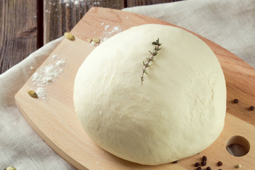 Ball of pizza dough on a rustic wooden background