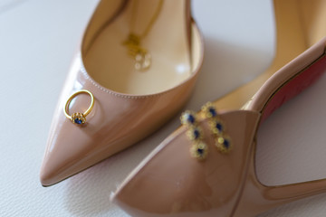 Ring and earrings on top of high heel shoes